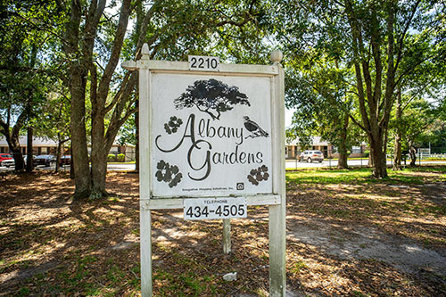 Wooden sign stating Albany Gardens