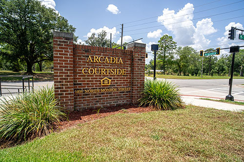 Brick sign stating Arcadia Courtside